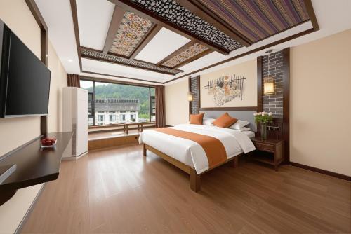 a bedroom with a bed and a large window at Lissen Hotel -5 min to Forest Park East Gate & Tour Tickets-Butler-recommended travel routes in Zhangjiajie
