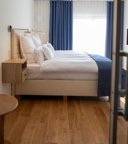a bed with white pillows and a window in a room at Gulfhof bei Kletzsch Apartments & Ferienwohnungen in Großefehn Ostfriesland in Großefehn 