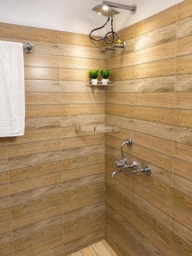 a bathroom with a shower with wooden walls at Nature View Retreat in Rishīkesh