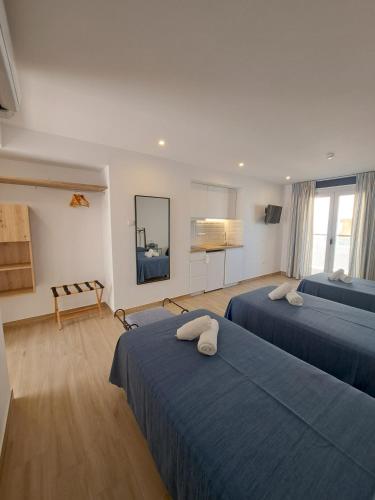 a hotel room with two beds and a television at Aparthotel ALMARIS in Es Pujols