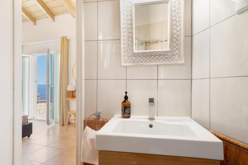 a bathroom with a white sink and a mirror at Villa Olivia Panoramic Sea View in Lefkada