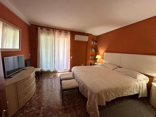 a bedroom with a bed and a flat screen tv at piso en puerto de Jávea in Jávea