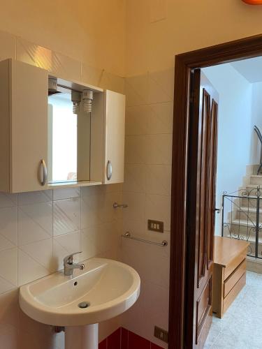 a bathroom with a sink and a mirror at Orsa Maggiore apartment with private courtyard in Uggiano la Chiesa