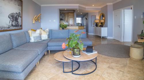 a living room with a blue couch and a table at 404 Oyster Rock - by Stay in Umhlanga in Durban