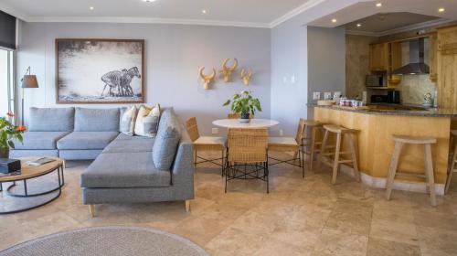 a living room with a couch and a kitchen at 404 Oyster Rock - by Stay in Umhlanga in Durban