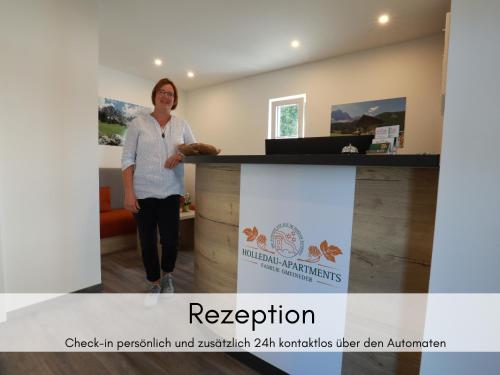 a woman standing next to a reception desk at Holledau-Apartments - Auszeit im schönen Hopfenland in Bayern - voll ausgestattete Apartments - Garten - Balkon - Nähe München in Osterwaal