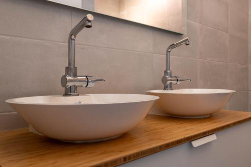 two sinks on a wooden counter in a bathroom at De Goudbalpeer - Ruim en luxe vakantiehuis voor 6 personen met uitzicht op wijngaard in Ruinerwold