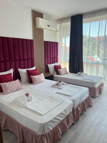 zwei Betten in einem Zimmer mit lila Wänden und Fenstern in der Unterkunft Dreams Family Hotel in Nessebar