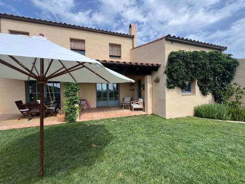 a white umbrella in the yard of a house at Villa with privat pool La Bisbal in Vulpellach