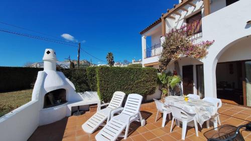 a patio with a table and chairs and a pizza oven at Hermitage 103 in Torroella de Montgrí