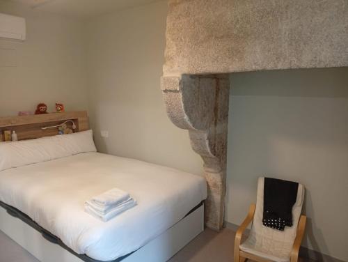 a small room with a bed and a chair at Loureiros Dorm in Santiago de Compostela