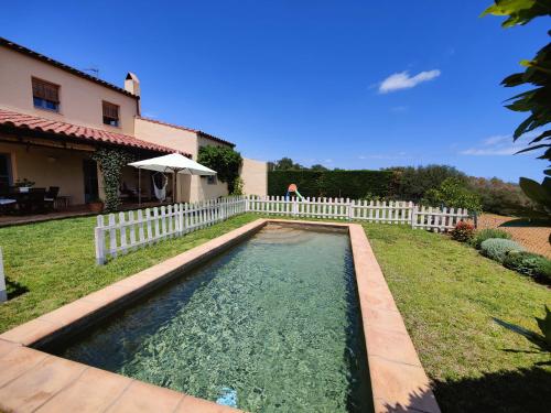 a pool in the yard of a house with a white fence at Villa with privat pool La Bisbal in Vulpellach