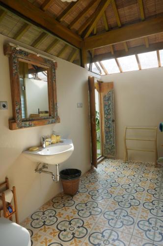 a bathroom with a sink and a mirror at Manggis Garden Dive Resort in Candidasa