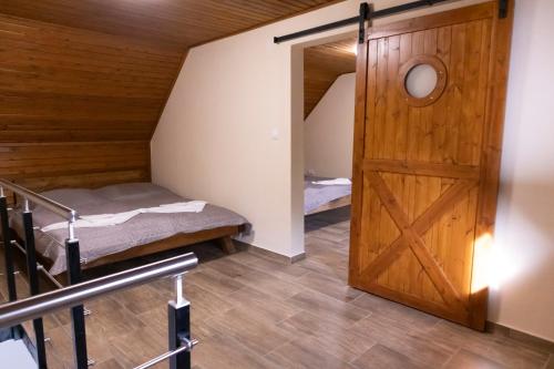 a room with a bunk bed and a wooden door at Tisza Apartman Mártély in Mártély