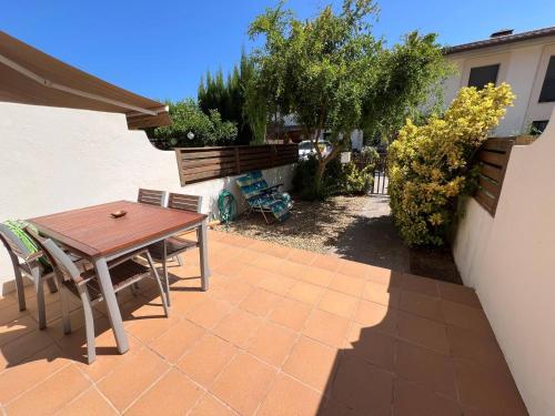 a patio with a wooden table and chairs at Sol Ric 13 in Torroella de Montgrí