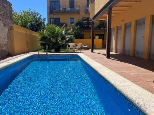 a large blue swimming pool next to a building at Ground floor apartment in Centre of Torroella De Montgri in Torroella de Montgrí