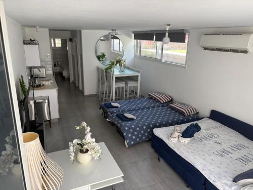a living room with two beds and a table at Apartment with private pool in Ashkelon