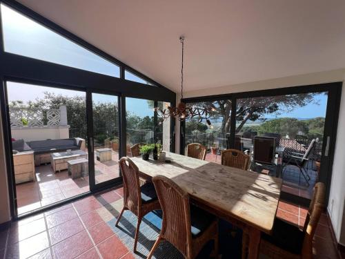a dining room with a table and large glass windows at Torre Vella 66 in Torroella de Montgrí