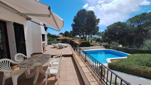 a patio with a table and chairs next to a swimming pool at TV 57 privat pool in Torroella de Montgrí
