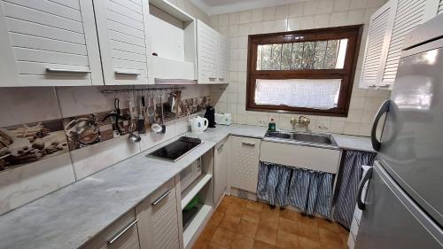 a kitchen with white cabinets and a sink and a refrigerator at La Font Lovely apartment LEstartit 400 meter from the beach in L'Estartit