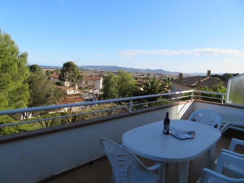 a table and chairs on a balcony with a bottle of wine at Casa Buckingham 27C in Torroella de Montgrí