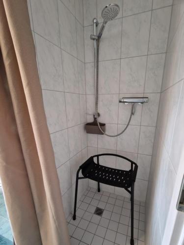 a shower with a black bench in a bathroom at FeWo Gisa - Graal Müritz in Graal-Müritz