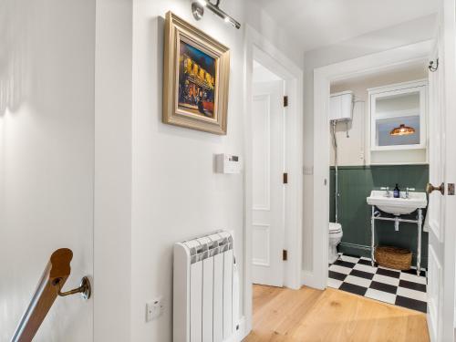 a bathroom with a radiator and a sink at The Old Forge Clifden in Clifden