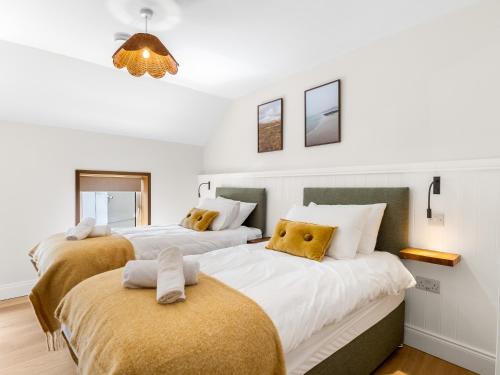 a bedroom with two beds with yellow pillows at The Old Forge Clifden in Clifden