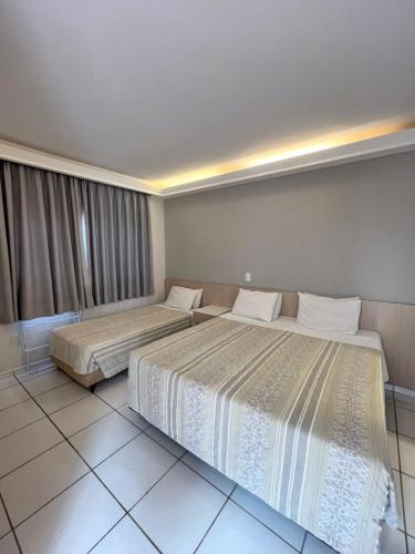 two beds in a hotel room with two bedsvisor at Atibaia Residence Hotel & Resort in Atibaia