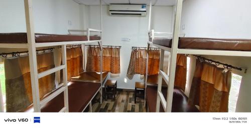 a room with two bunk beds and curtains at The Rail Coach in Jhānsi