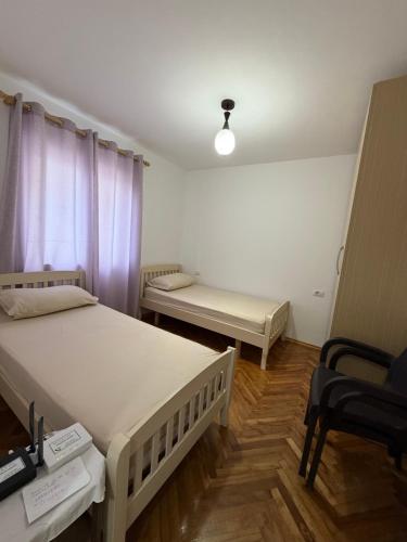 a room with two beds and a bench in it at Guest House Central Vlora in Vlorë
