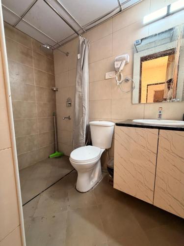 a bathroom with a toilet and a shower and a sink at Casa sol Goa 2BR Apt By Amoret Homes in Chicalim