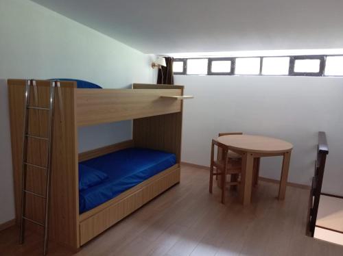 a bunk bed in a room with a table and a stool at Il rifugio della Presolana in Castione della Presolana