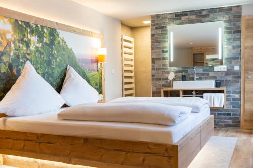 a bedroom with a large bed and a mirror at Gasthaus Winzerstube & Hotel in Rödelsee