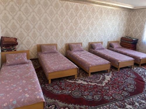 a living room with three couches and a rug at Mamyr Guest House in Sary-Mogul