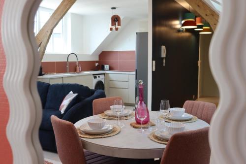 a dining room table with plates and wine glasses at Grand Appartement ultra moderne Plein Centre, plage à pieds, avec parking in Concarneau