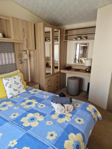 a bedroom with a blue bed with flowers on it at Sunblast- Dawlish Warren in Cockwood