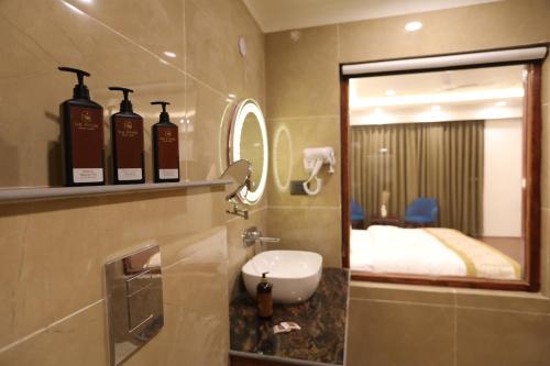 a bathroom with a sink and a mirror and a bed at The Pamir Hotel in Nubra