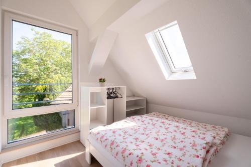 a white bedroom with a bed and a window at Häusle Fritz in Weier