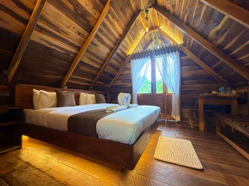 a bedroom with a bed in a wooden house at Mr Arachchi Luxury Cabana in Ella