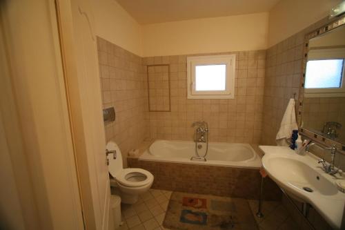 a bathroom with a tub and a toilet and a sink at Chalkida Apartments in Chalkida