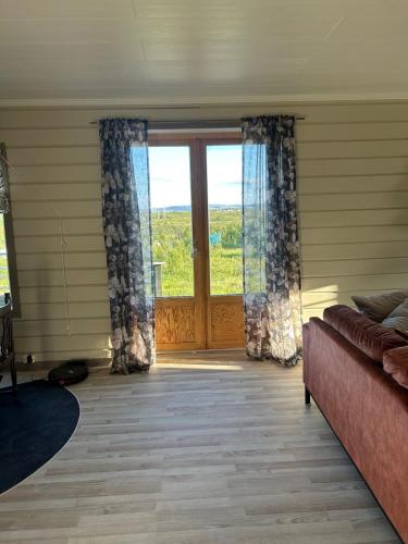 a living room with a couch and a large window at Varangerfjord Stay in Varangerbotn
