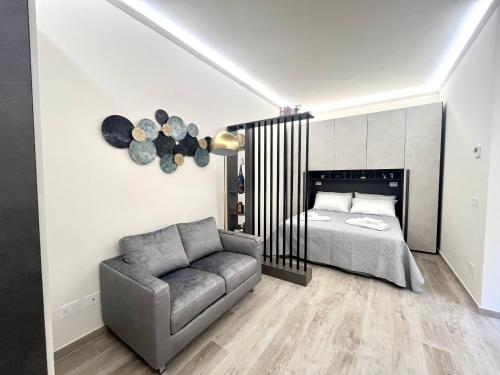 a bedroom with a bed and a couch at Garibaldi Living - Centro Storico Parma in Parma