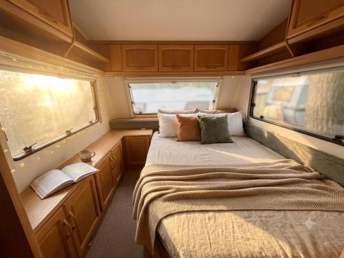 a bedroom with a bed and two windows in an rv at Waldkiez Tiefensee in Tiefensee