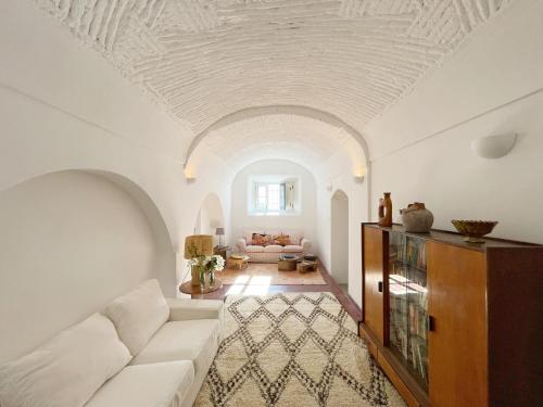 a living room with a white couch and a ceiling at Casa Pimenta in Vidigueira