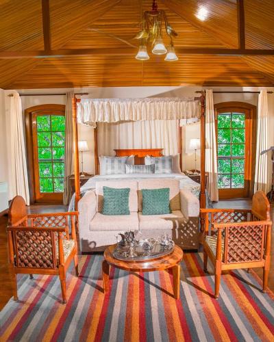 a living room with a bed and a couch at WelcomHeritage Ashdale in Nainital