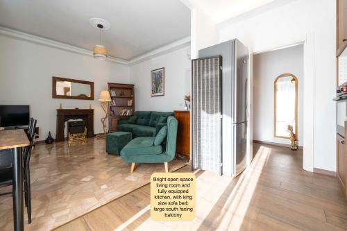 a living room with a green couch and a refrigerator at Charming king appartment with balcony and jacuzzi in Como