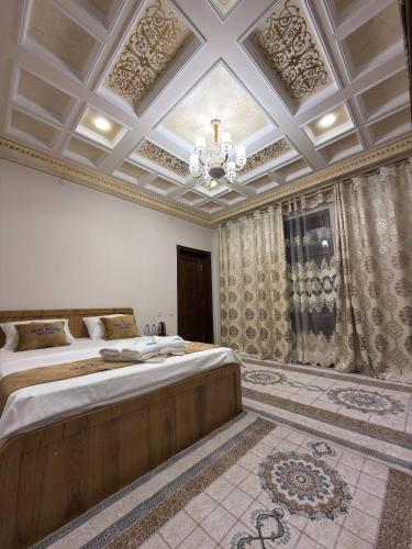 a bedroom with two beds and a ceiling with a chandelier at Silk Road Hostel in Bukhara