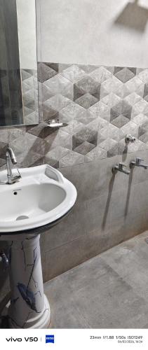 a bathroom with a sink and a mirror at Shree radhe palace in Datia