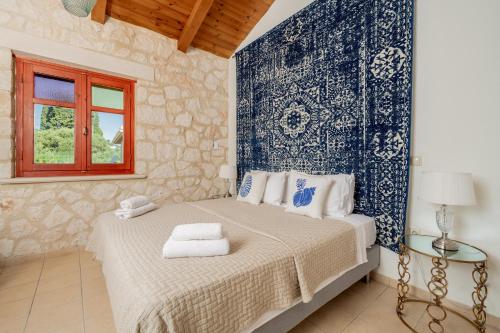 a bedroom with a bed with a blue and white wall at Nephele 3 bedroom villa with private pool in Akrotiri